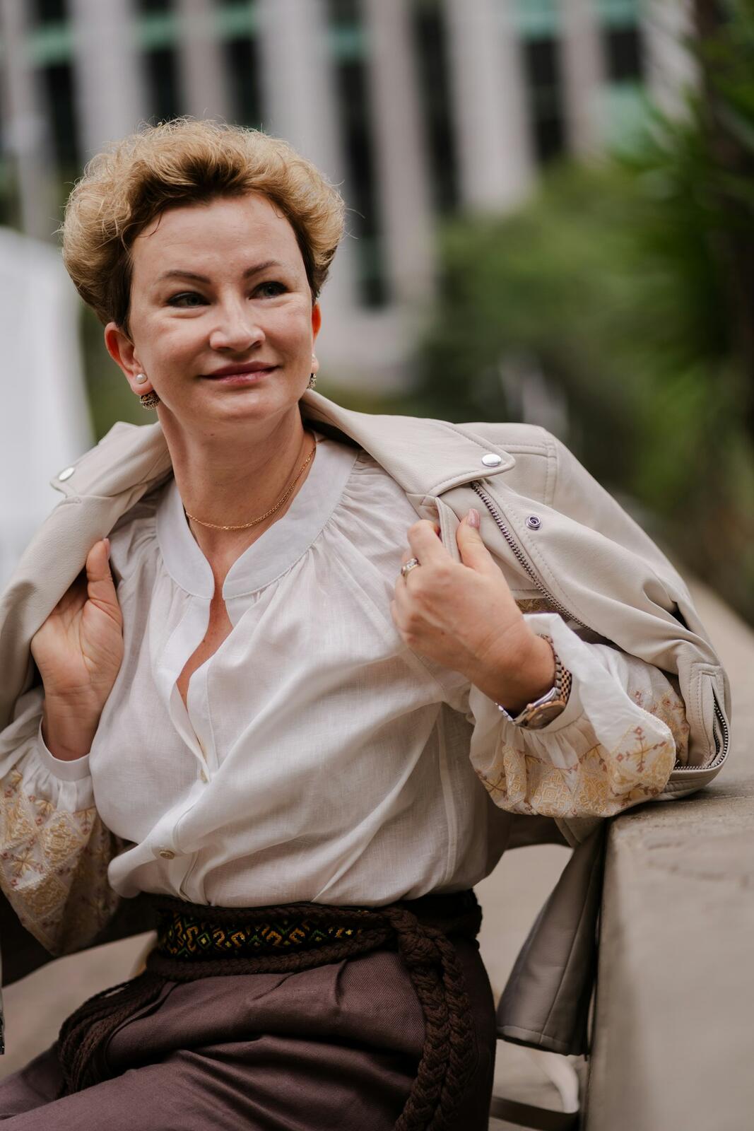 Femme en blouse blanche et veste en cuir